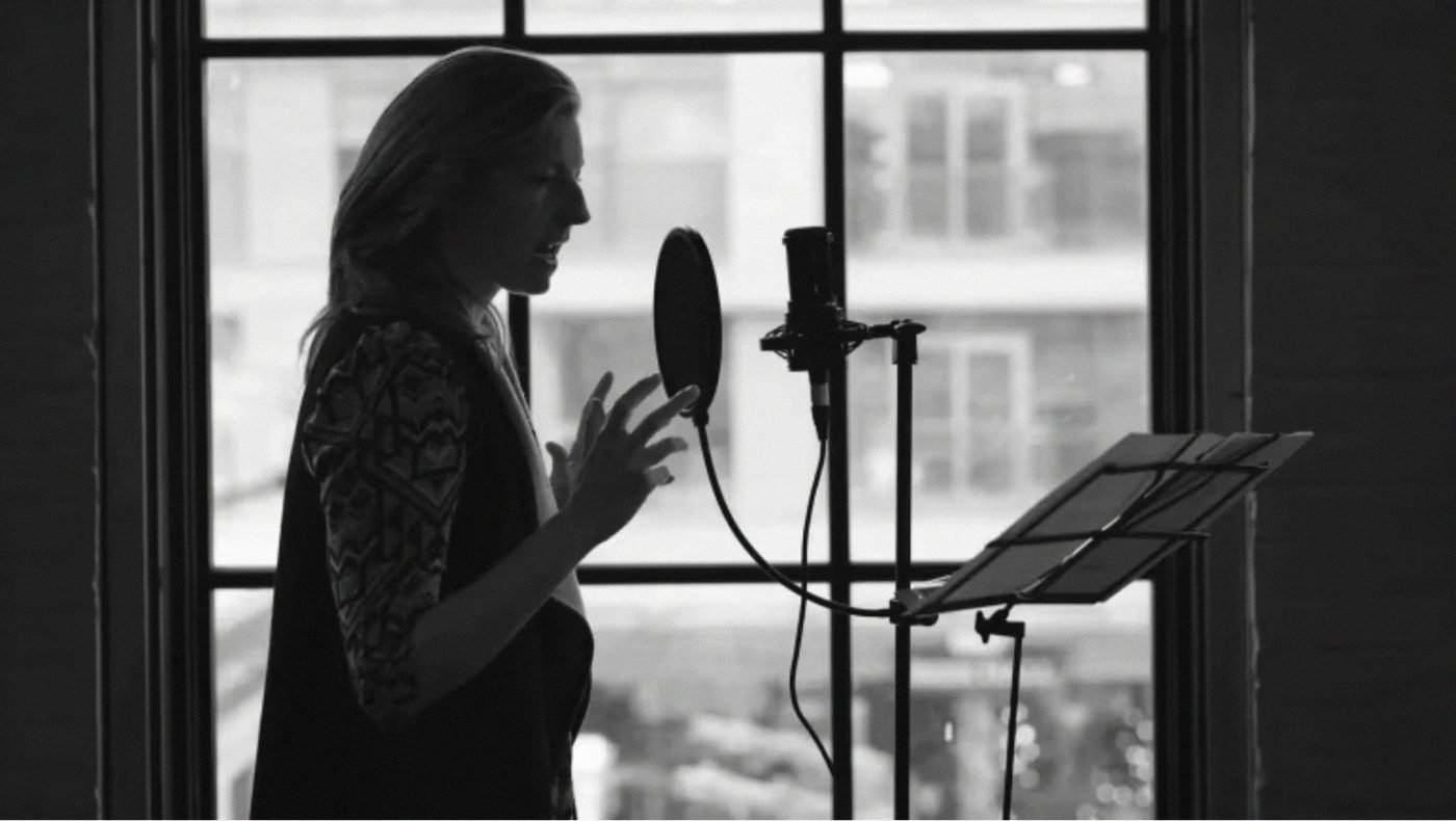 An actor recording a PlayME session at the microphone.